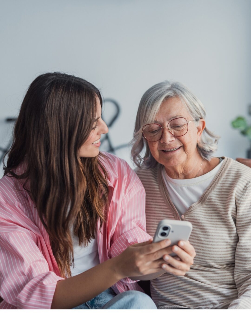 A woman showing an older relative something on a phone